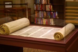 Old Testament Torah scroll on display under glass case
