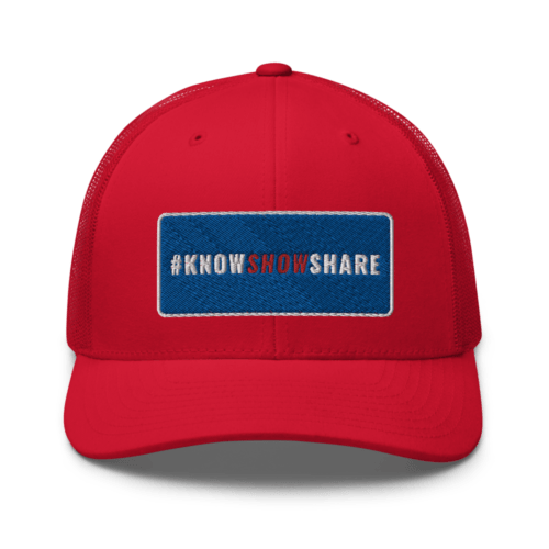 Red trucker cap with hashtag Know Show Share inside a blue rectangle with white border